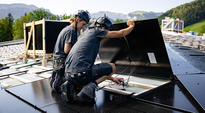Zwei Solarinstallateure arbeitet auf Steildach und installierte eine Solaranlage Gebäudehülle Schweiz